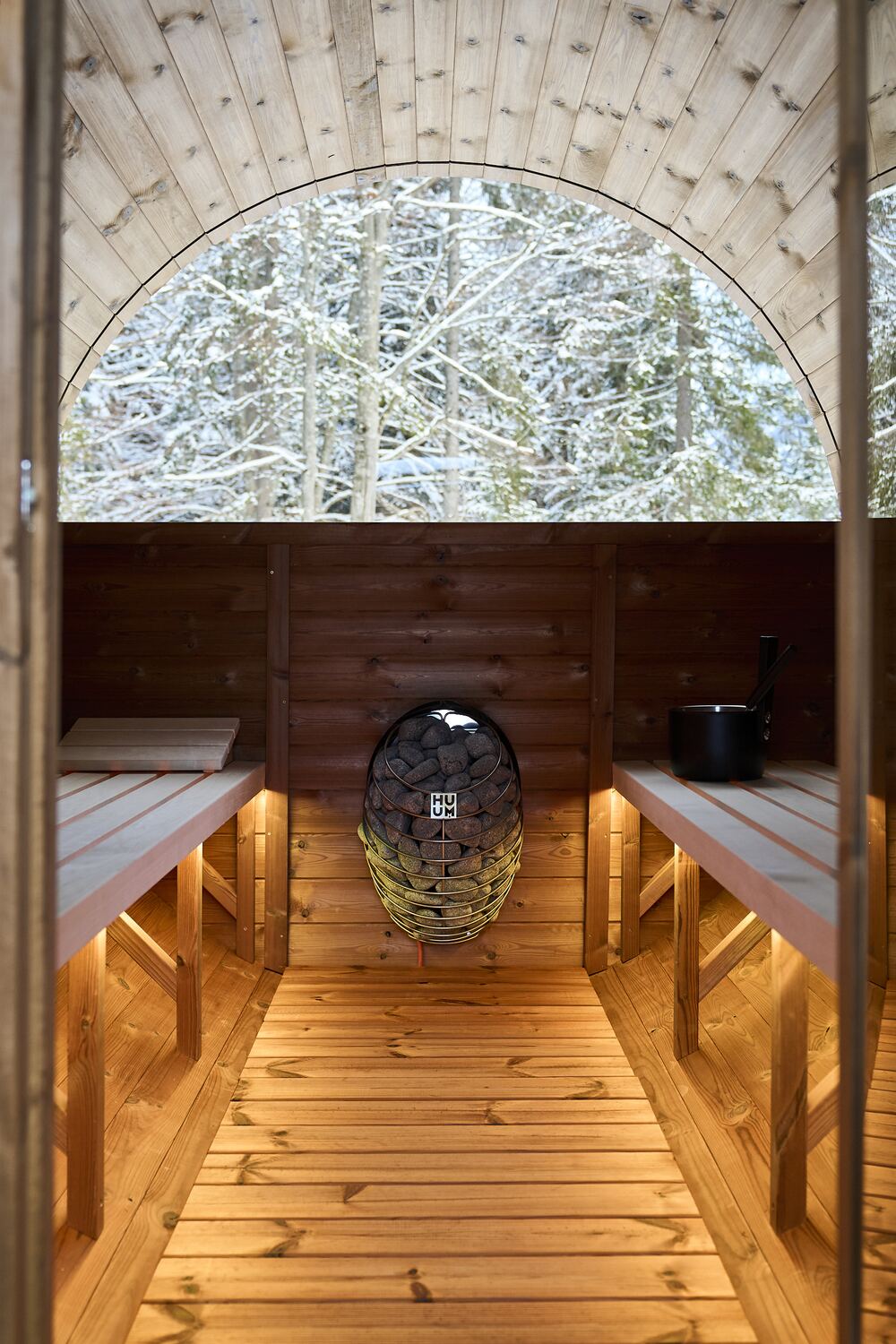 Vista dalla sauna a botte attraverso l'oblò sul bosco d'inverno